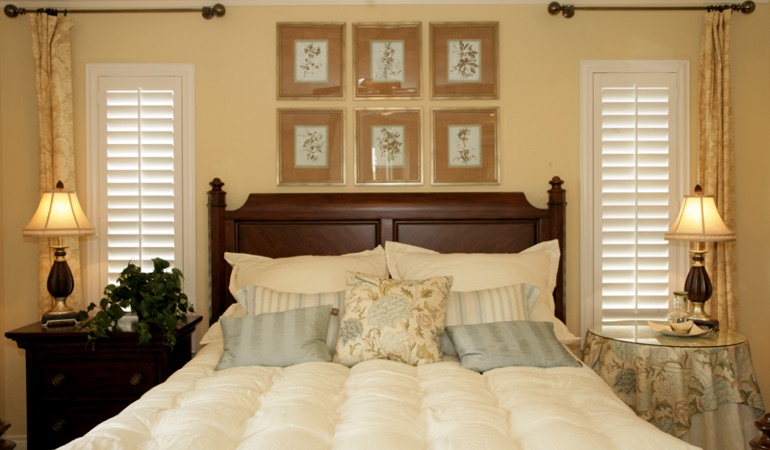 Tall plantation shutters framing bed in a bedroom in New York City 